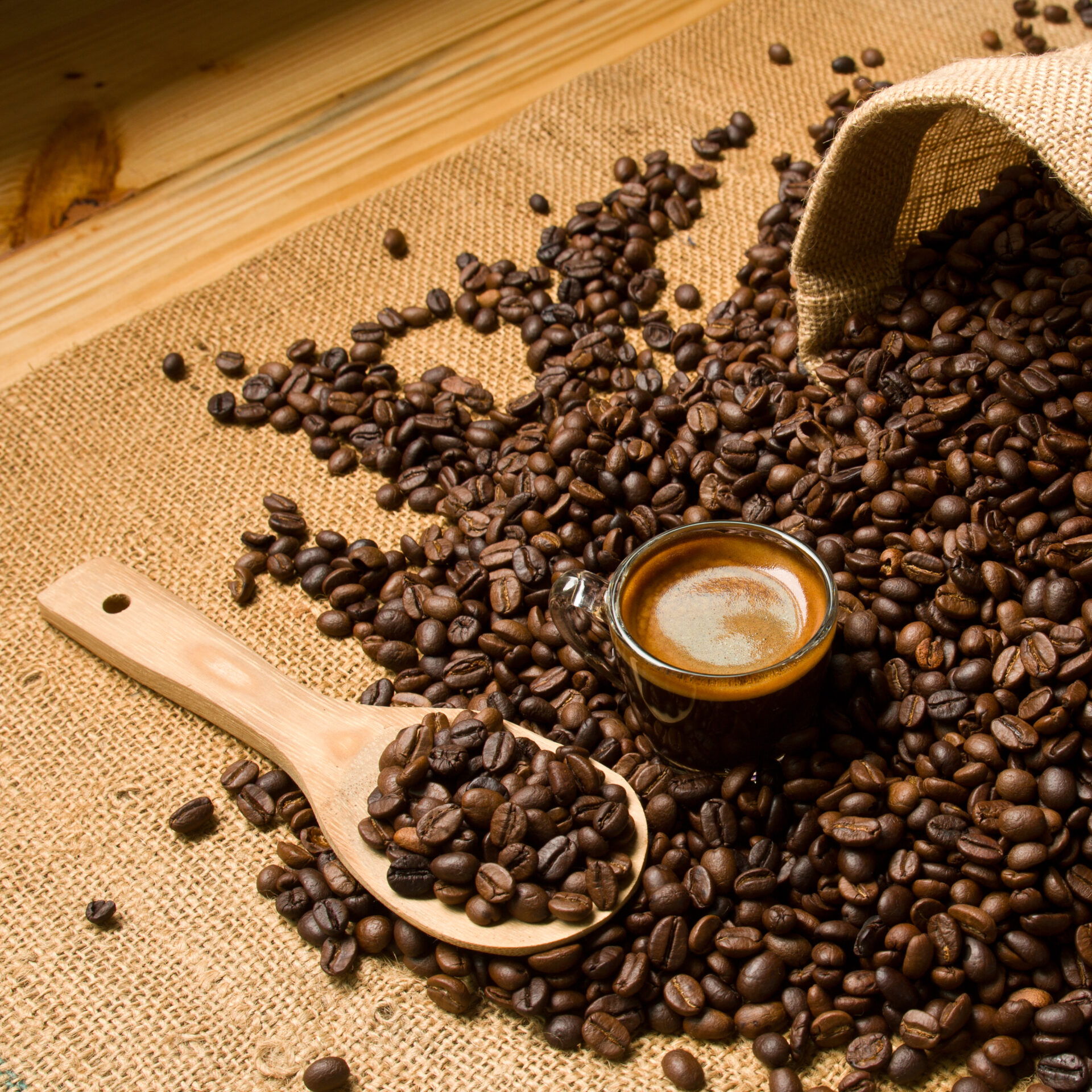 espresso with wood scoop and coffee beans in burlap